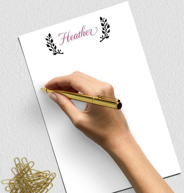 Personalized notepad with laurel design.