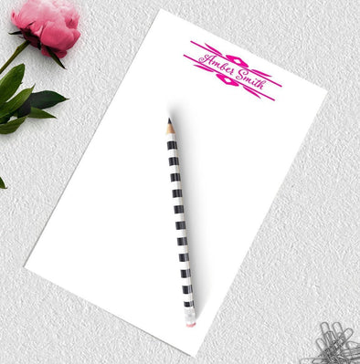 Personalized decorative notepad with pink ink.
