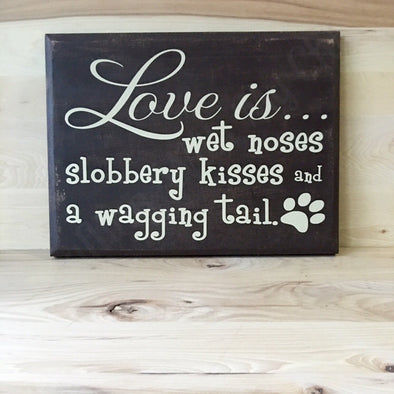 Love is wet noses slobbery kisses and a wagging tail wooden sign.